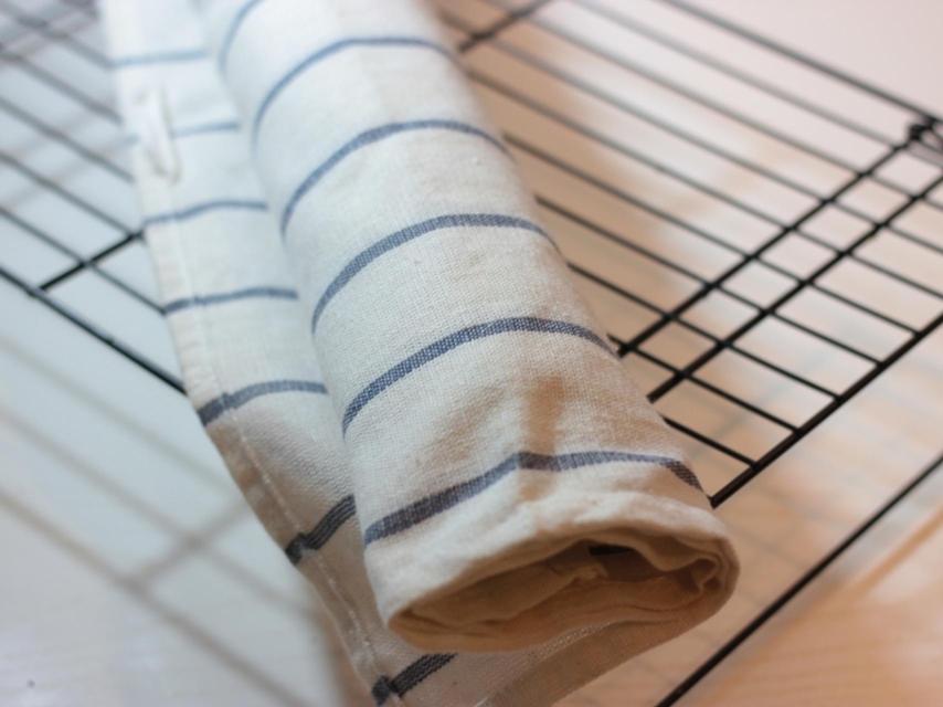 Una plancha de bizcocho envuelta en un trapo de cocina para hacer un brazo de gitano