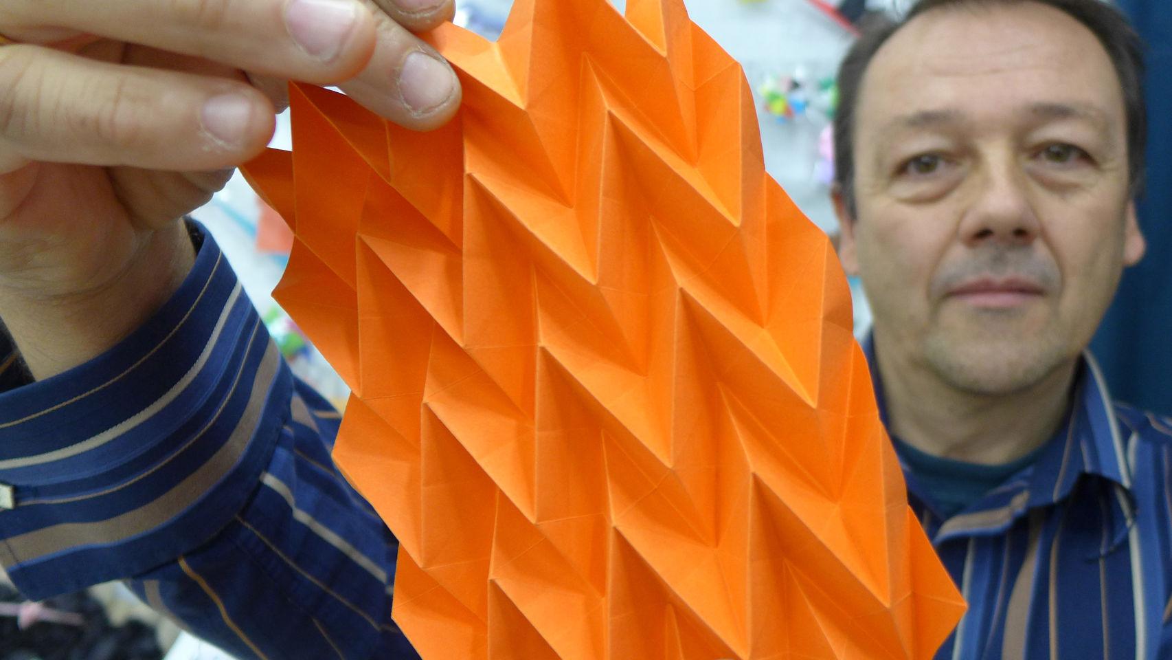 El arquitecto Manuel Carrasco sostiene un papel doblado con el pliegue Miura.