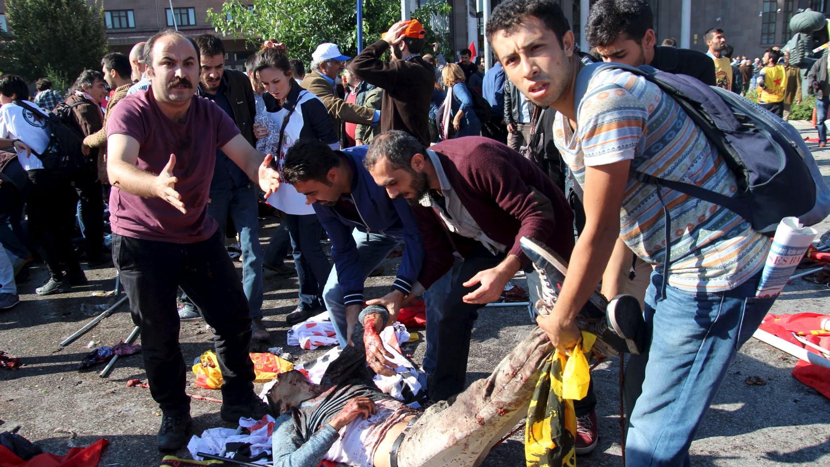 Tratan de trasladar a un hombre herido en el atentado.