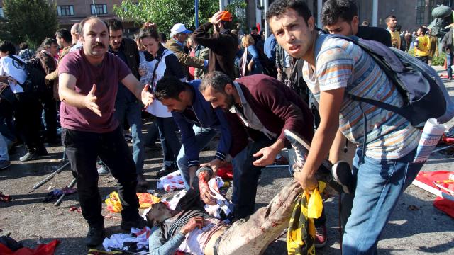 Tratan de trasladar a un hombre herido en el atentado.