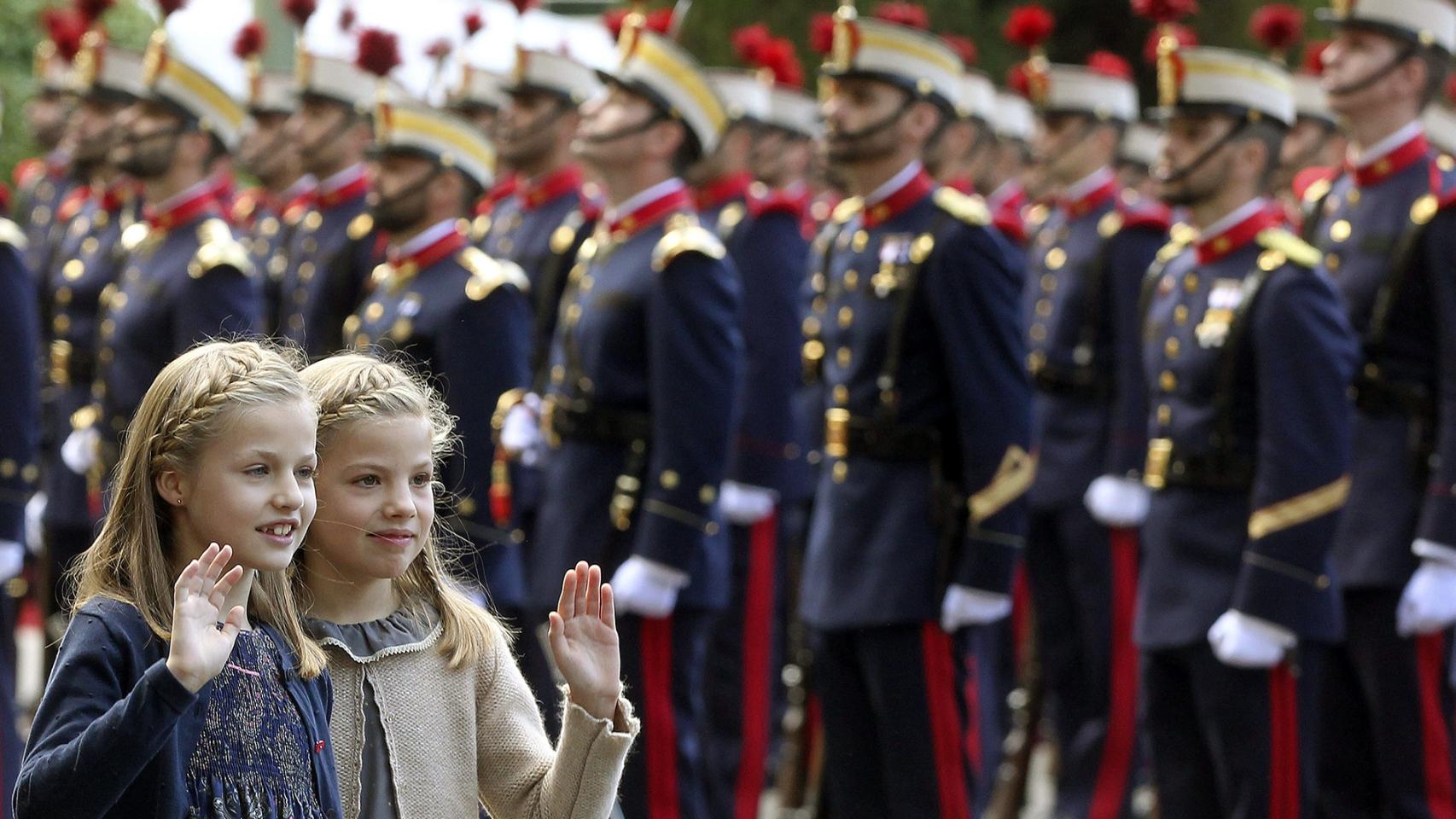 Las infantas saludan a su llegada al desfile.