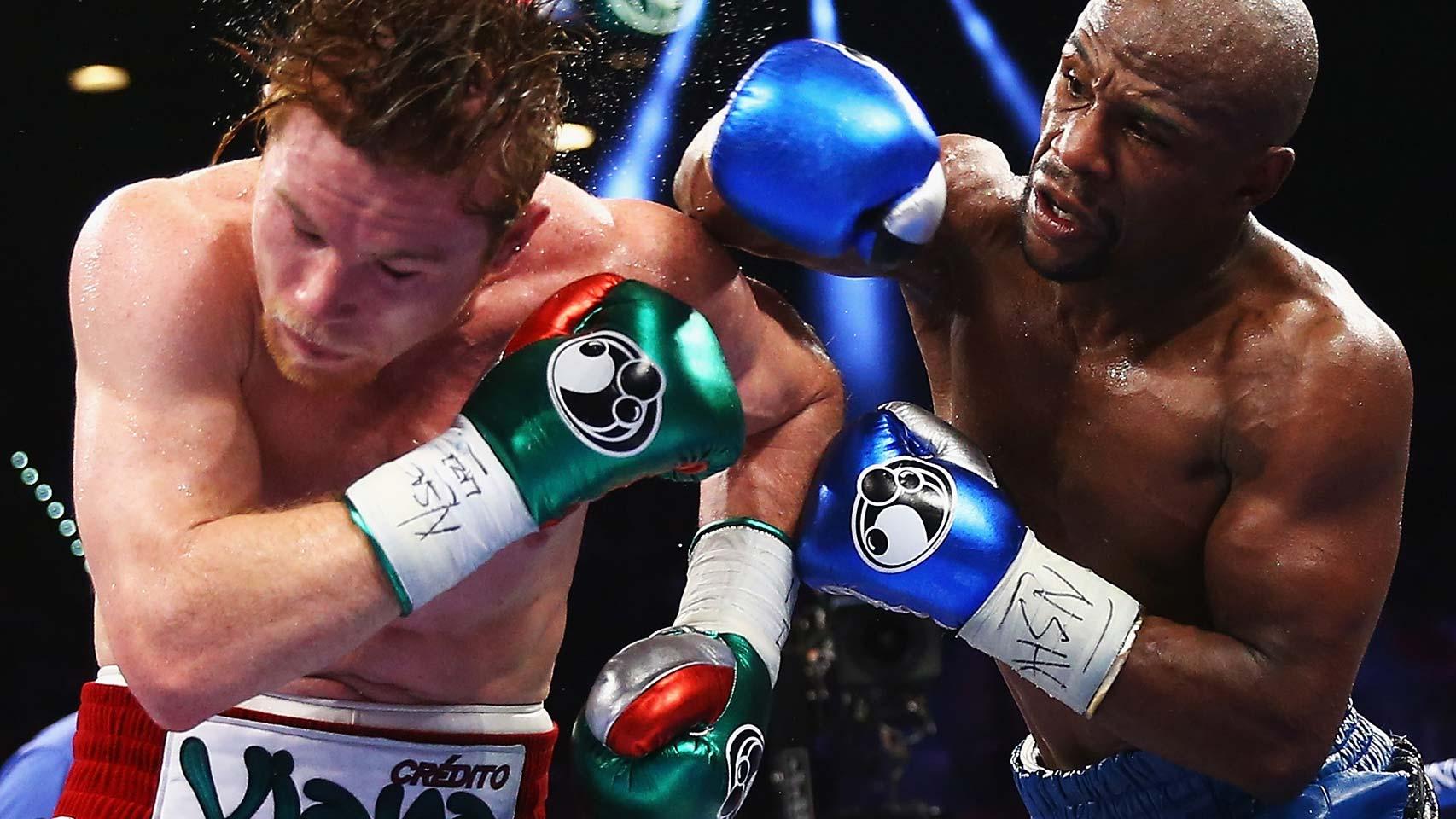 Floyd Mayweather golpea a Canelo Álvarez.