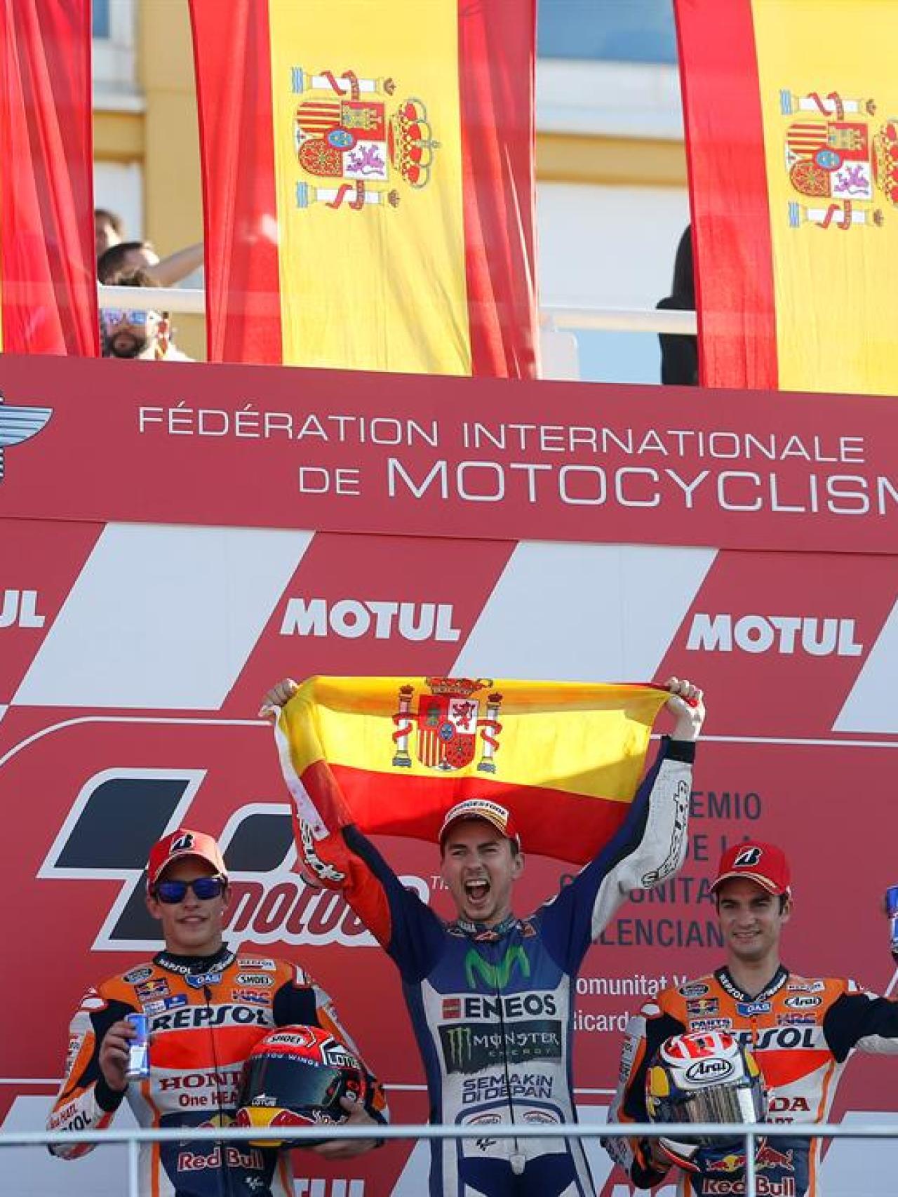 Lorenzo celebra en el podio rodeado de banderas españolas.