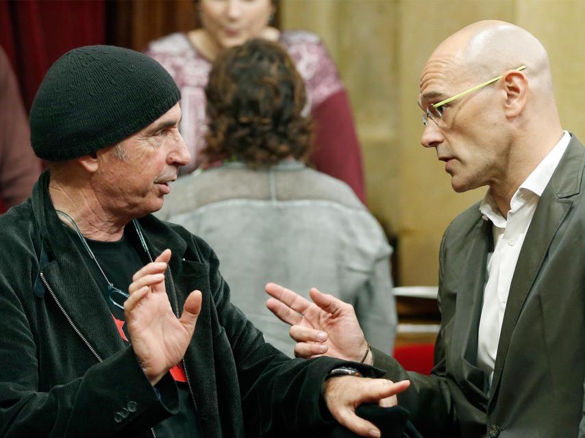 Los diputados de Junts pel Sí, Raúl Romeva  y Lluis Llach (i), en el hemiciclo.