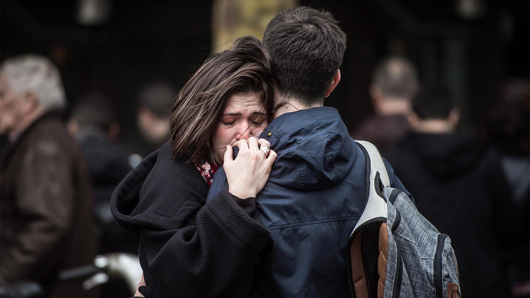 Una pareja se abraza cerca de uno de los cafés atacados.