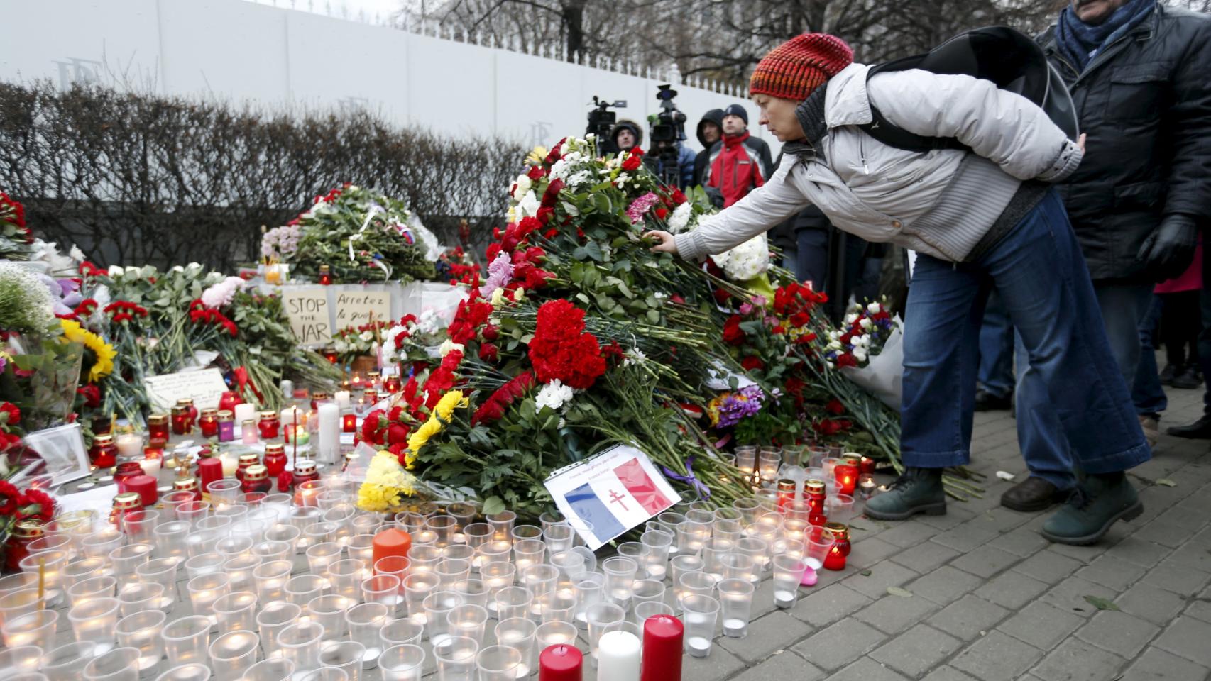 Una mujer coloca flores cerca de la embajada francesa en Moscú