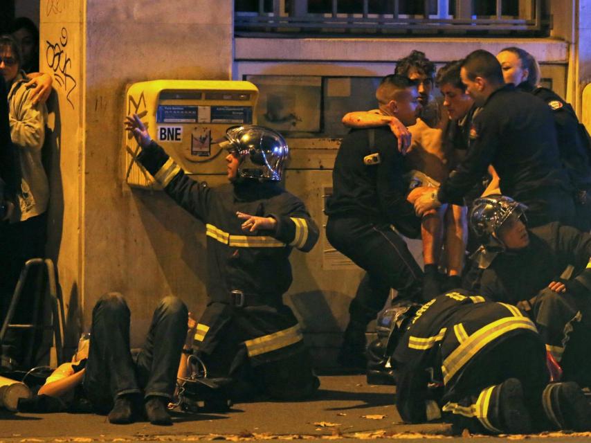 Los bomberos asisten a un herido cerca de la sala Bataclan.