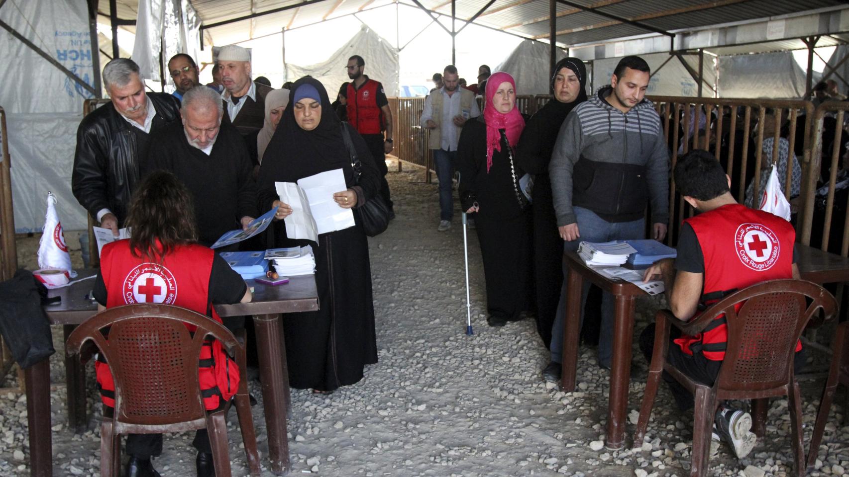 Refugiados sirios hacen cola en un centro de Acnur.