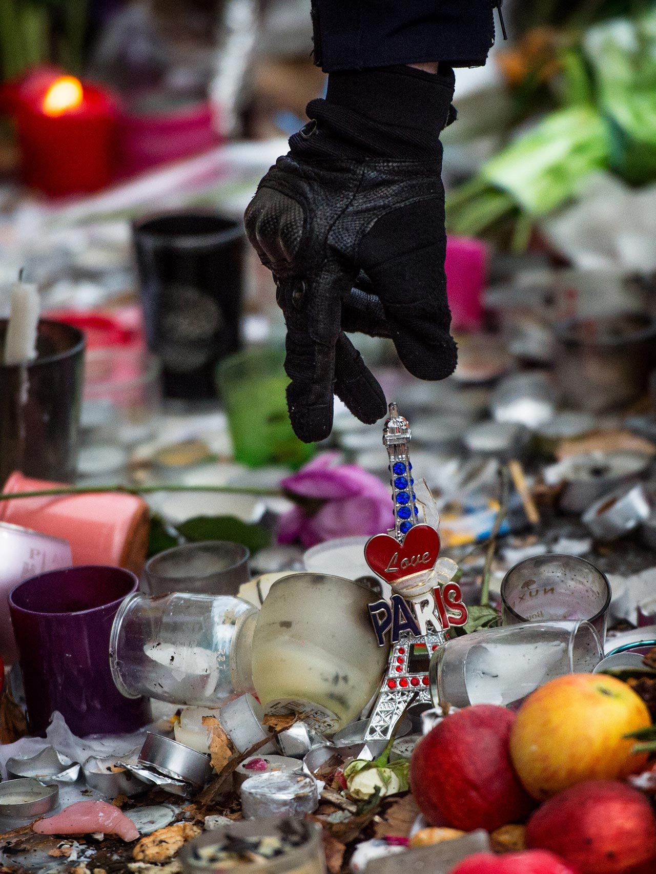 Un policía retira una torre Eiffel dejada como muestra de duelo
