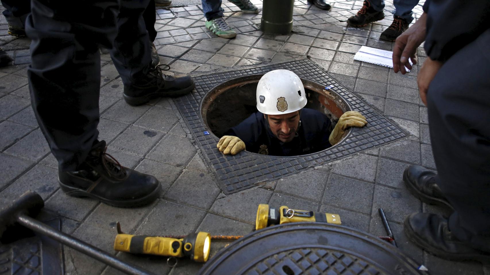 Un policía comprueba una alcantarilla cercana al Santiago Bernabéu.