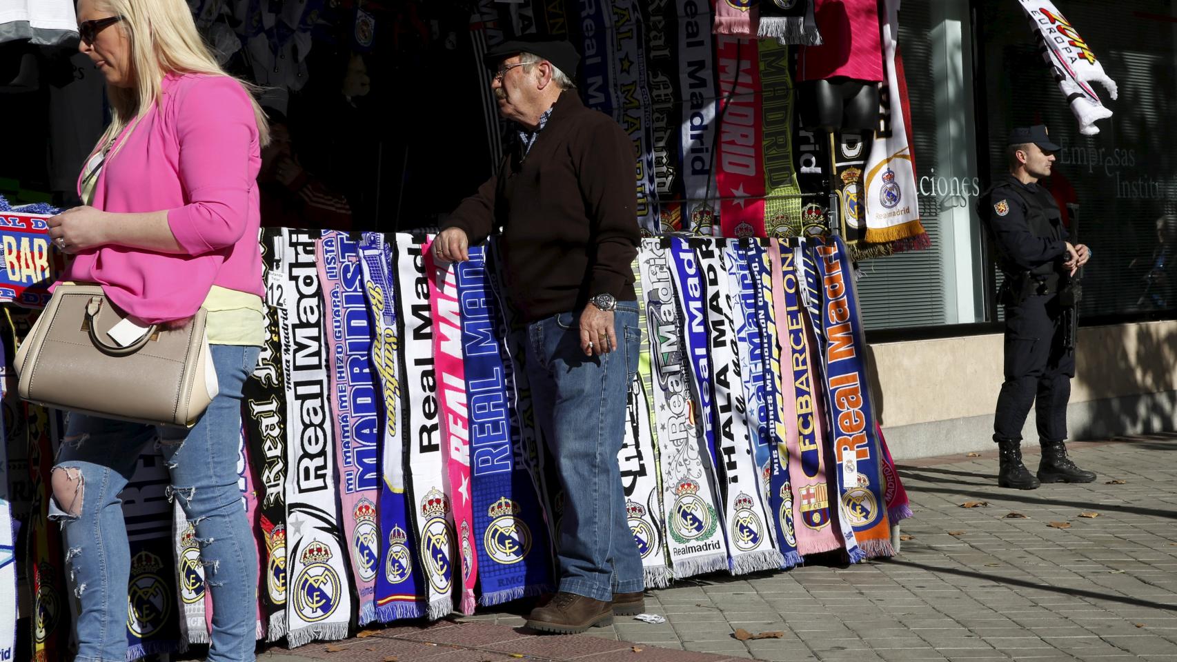 Un ciudadano se acerca a uno de los puestos de merchandising cercano al estadio.
