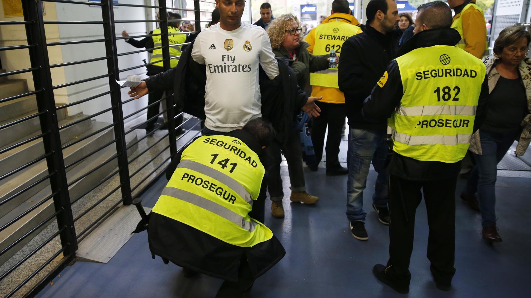 Los aficionados son cacheados por agentes policiales antes del Clásico.