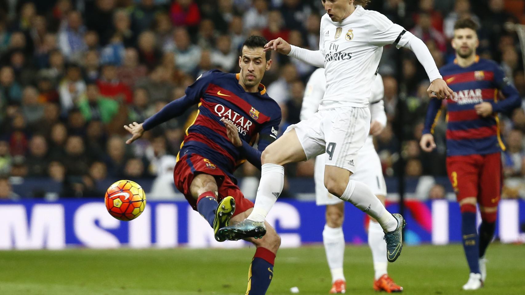 Busquets y Modric pelean por el balón durante el Clásico.