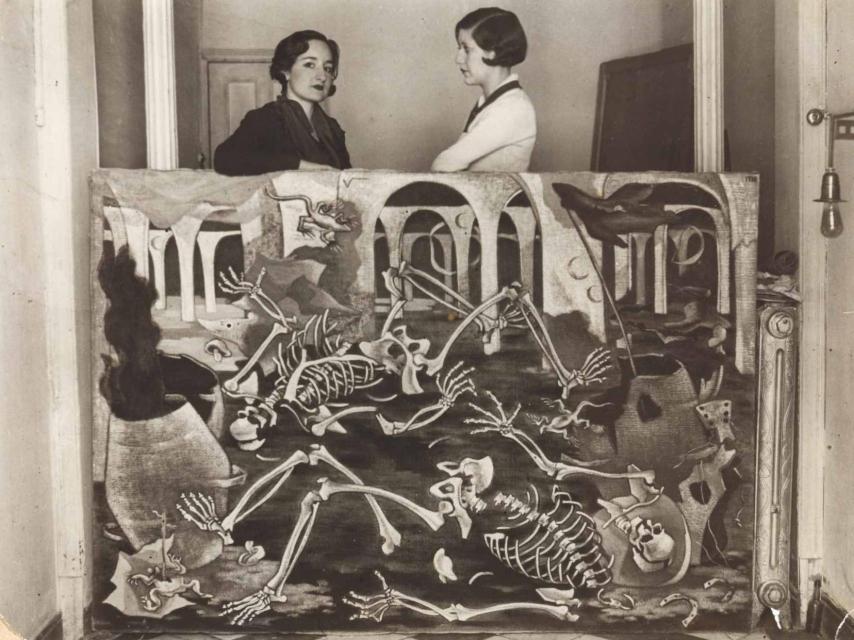 Maruja Mallo con Josefina Carabias, apoyadas sobre su óleo ‘Antro de fósiles’.