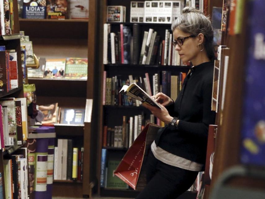 Una mujer leyendo en una librería.