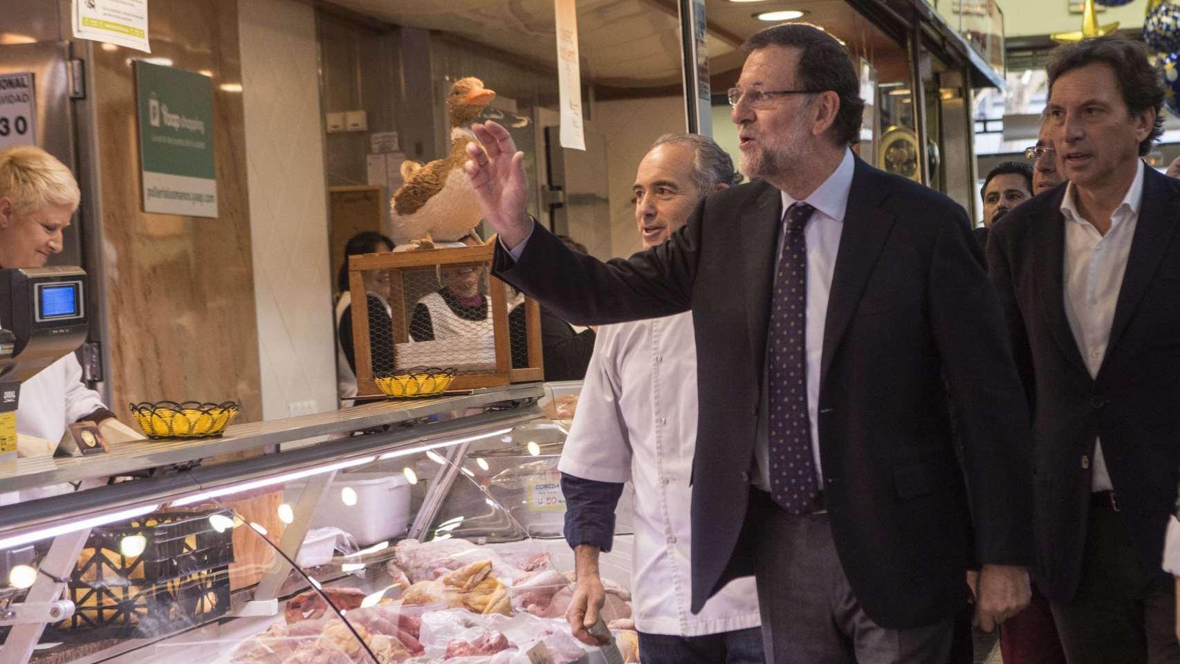Mariano Rajoy junto al número uno de la lista del PP balear al Congreso, Mateo Isern, en su visita al mercado del Olivar en Mallorca