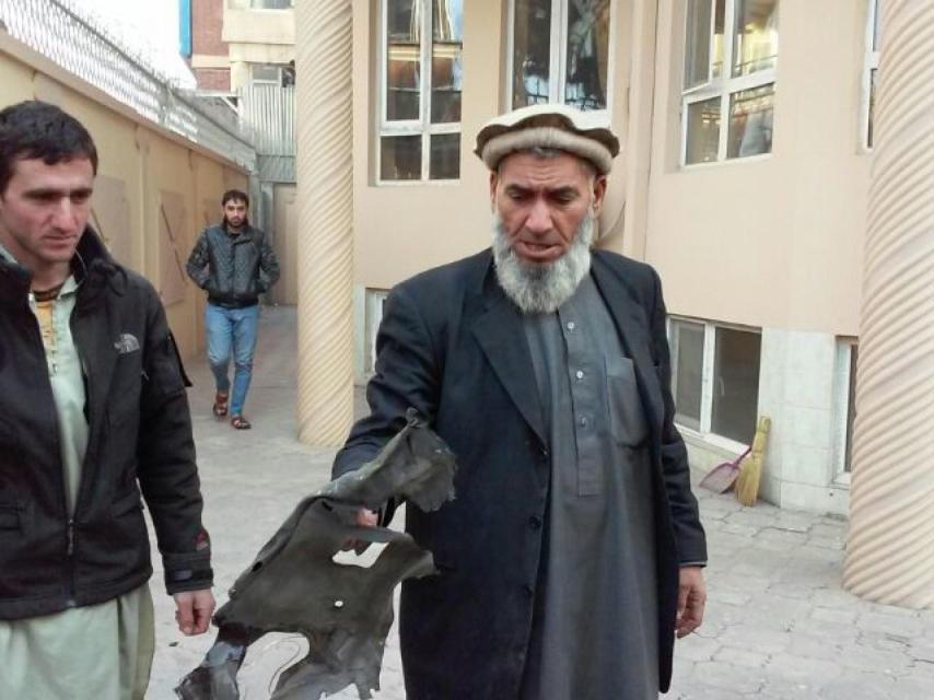 Abdur Rahman sostiene una pieza del coche explotado.