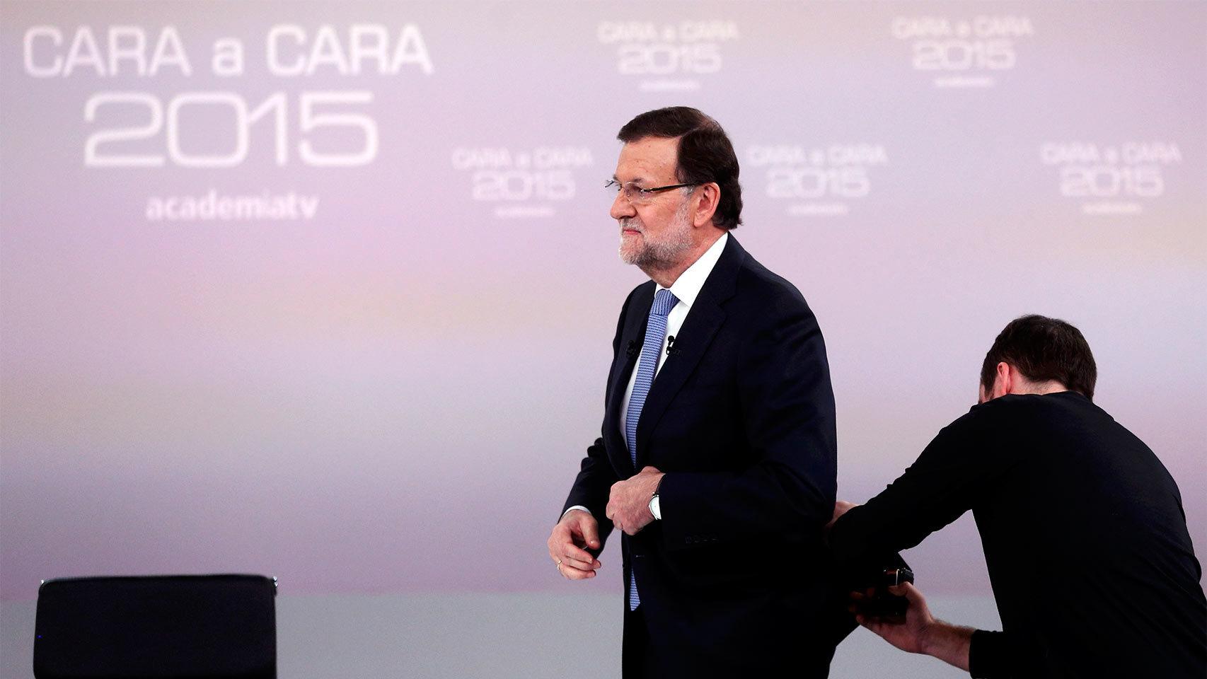 Un operador coloca el micrófono a Rajoy.