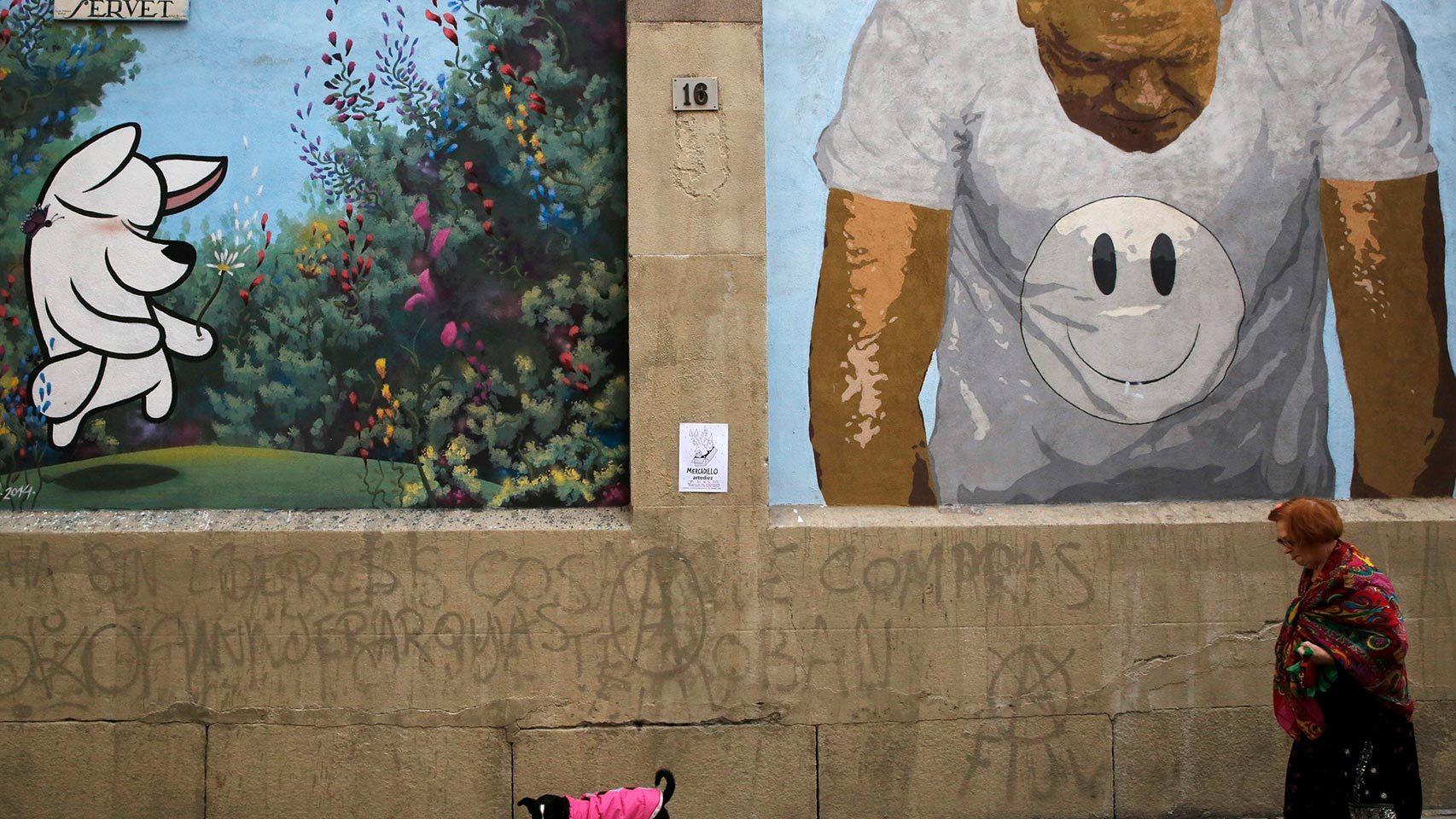 Una mujer pasea a su perro por las calles de Madrid.