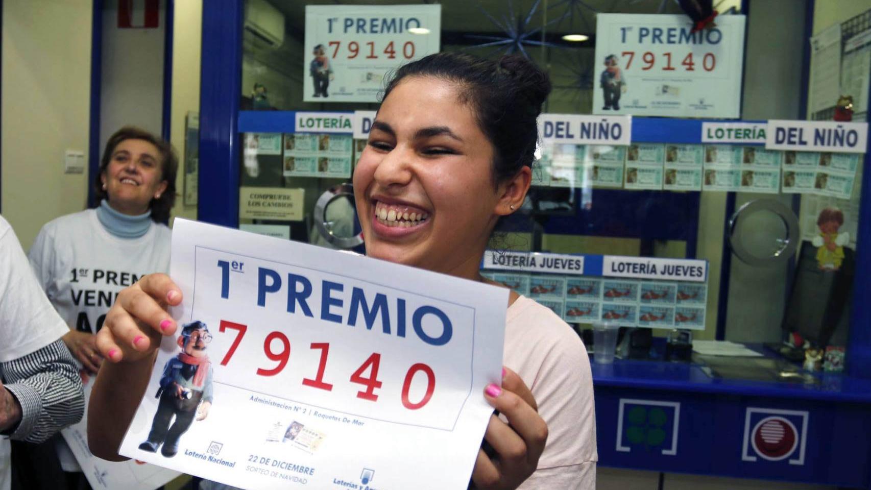 La joven de origen marroquí sostiene un cartel con el número premiado.