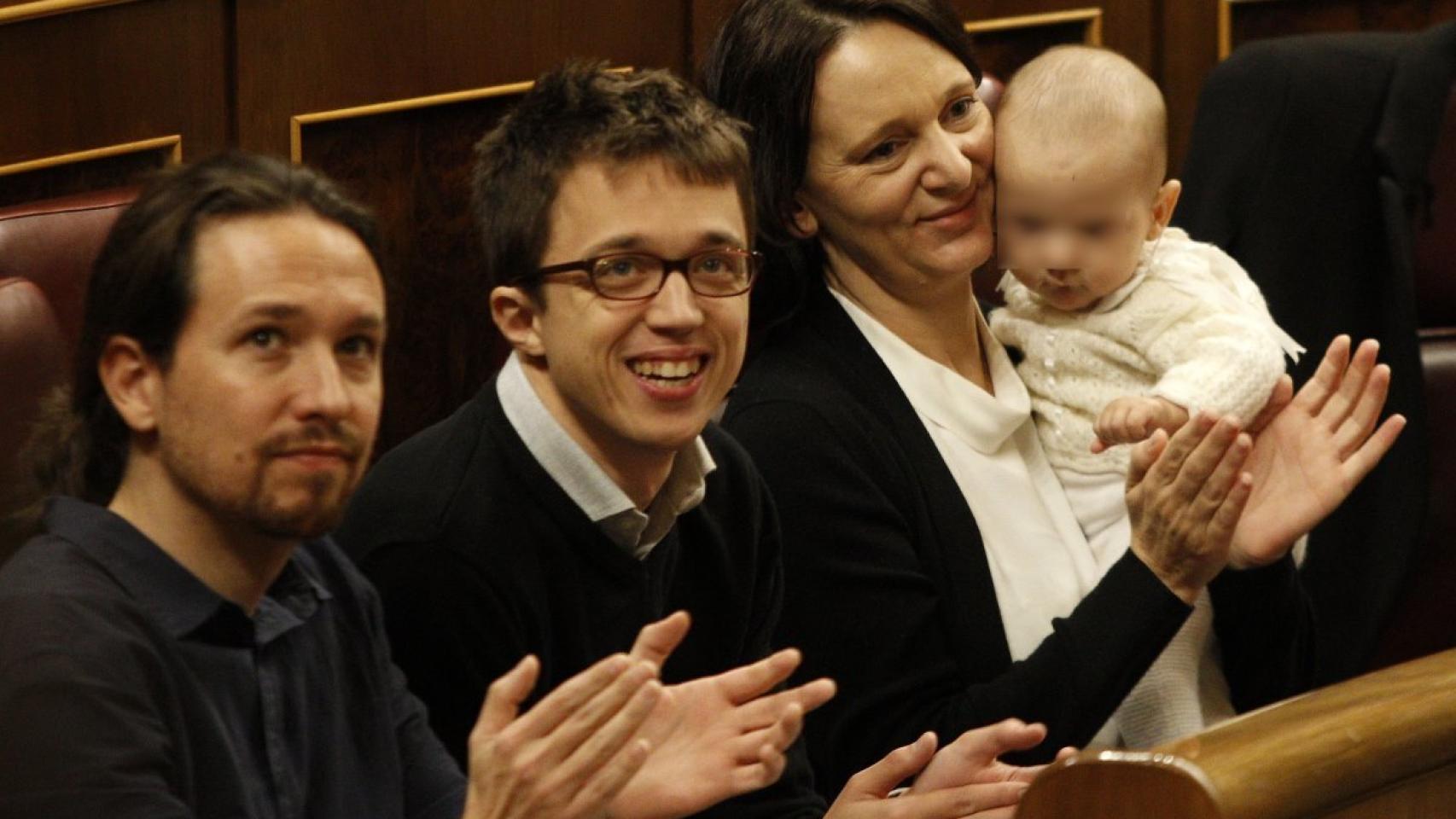 Carolina Bescansa sujeta en brazos a su bebé, con Iñijo Errejón y Pablo Iglesias a su lado.