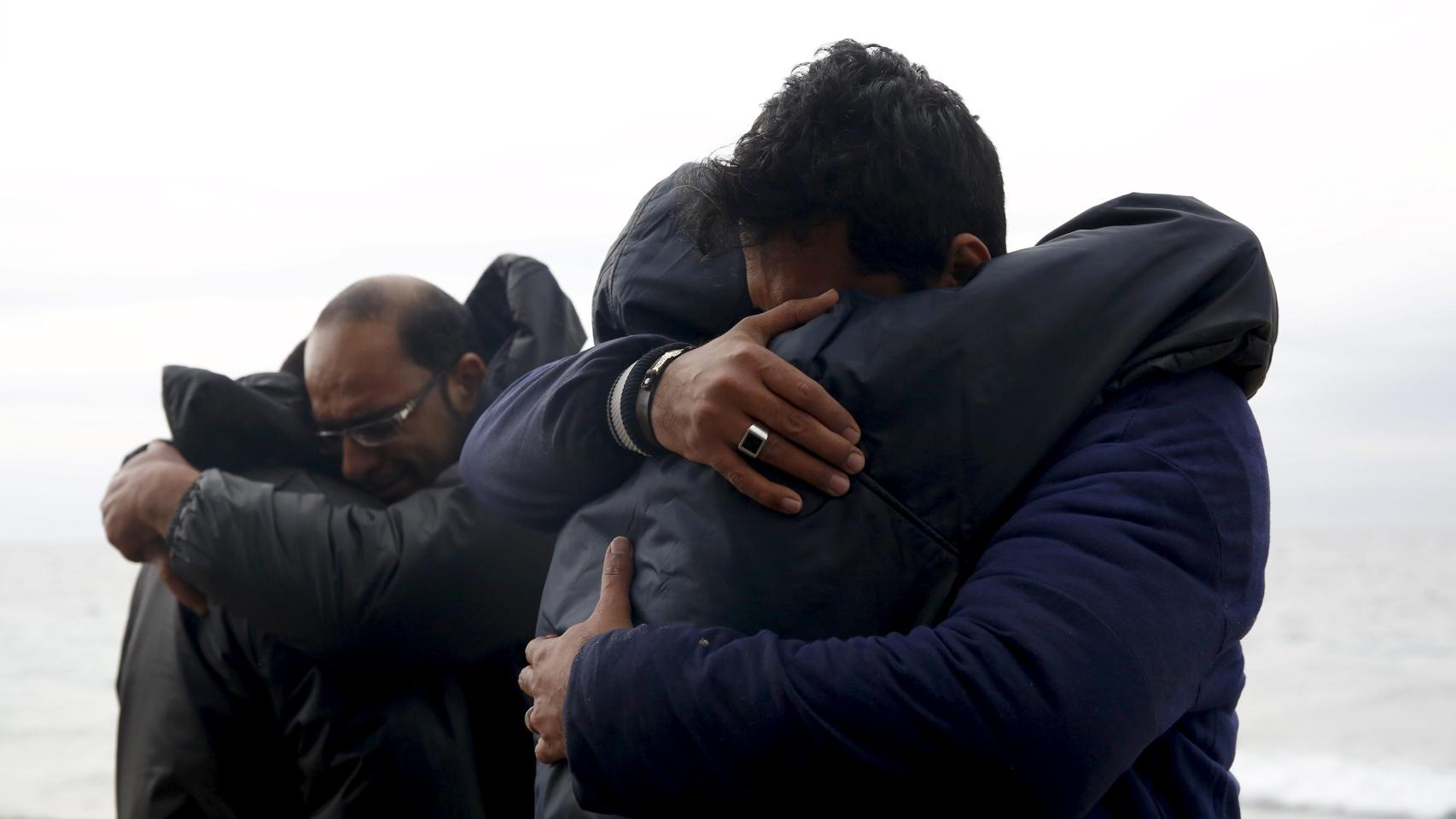 Refugiados se abrazan tras conseguir llegar a Lesbos sanos y salvos.
