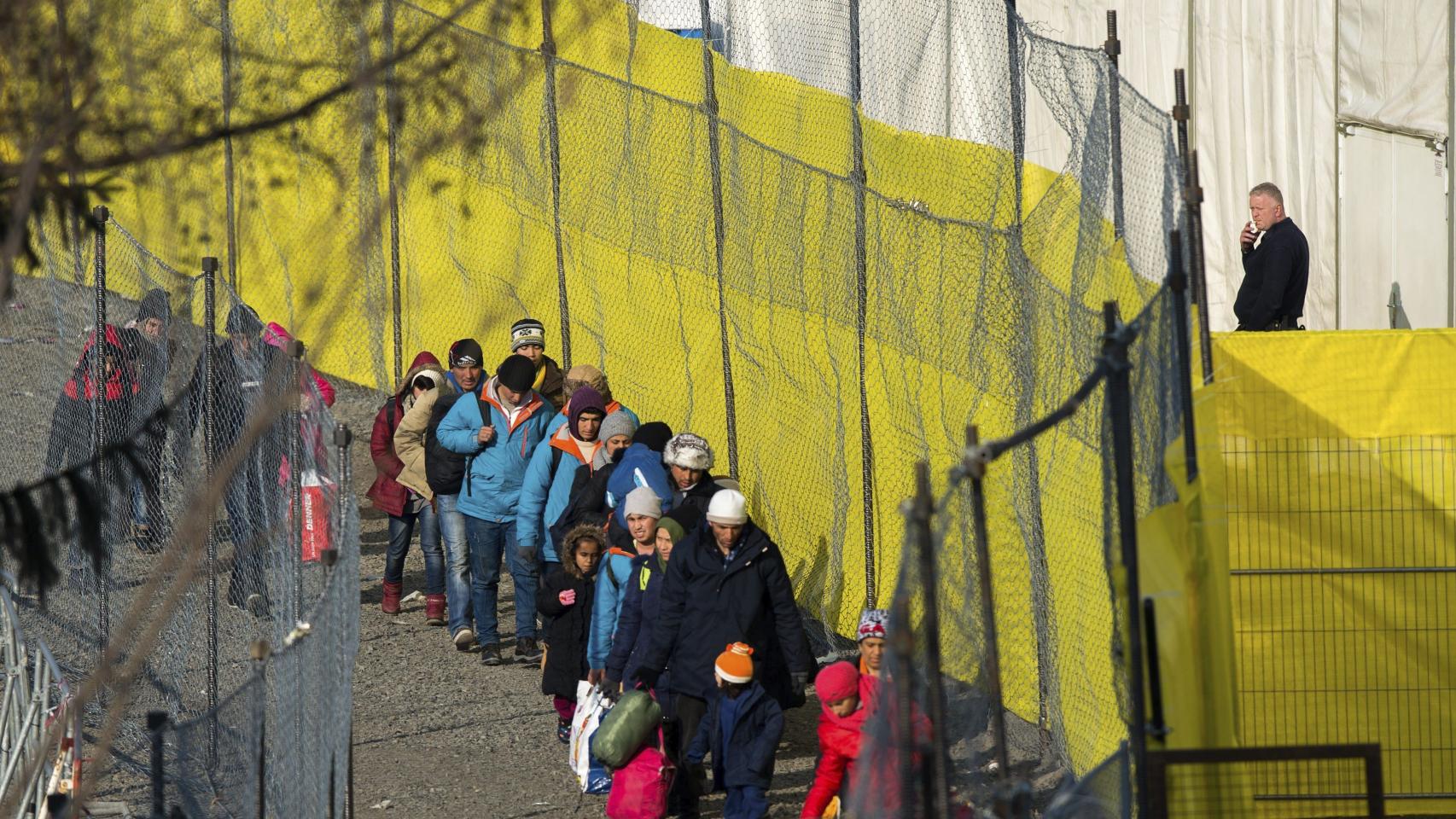 Refugiados caminan junto a una valla en la frontera de Austria con Eslovenia.