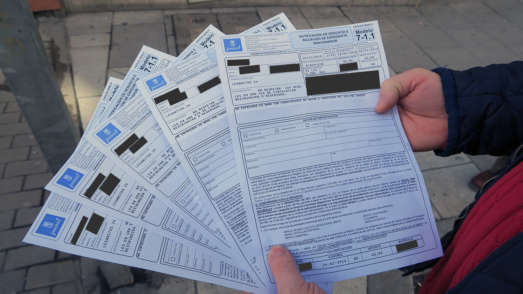 Un afectado muestra cinco de sus siete multas en la calle Leganitos de Madrid