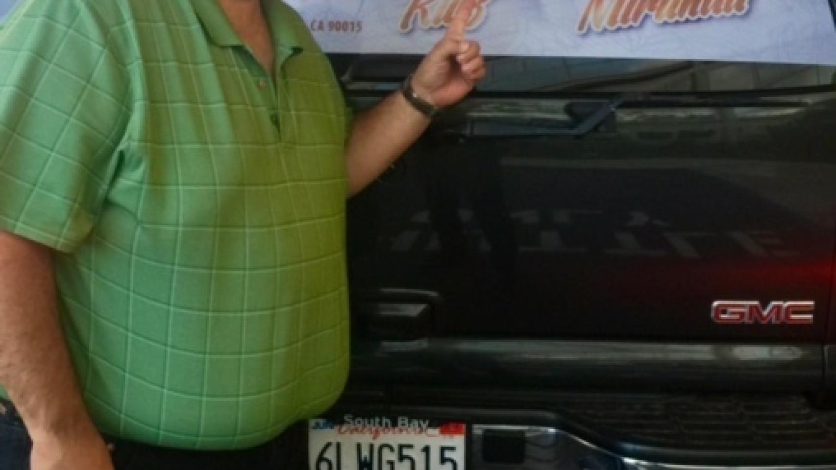 el cantante Maelo Ruiz señala la furgoneta de su gira