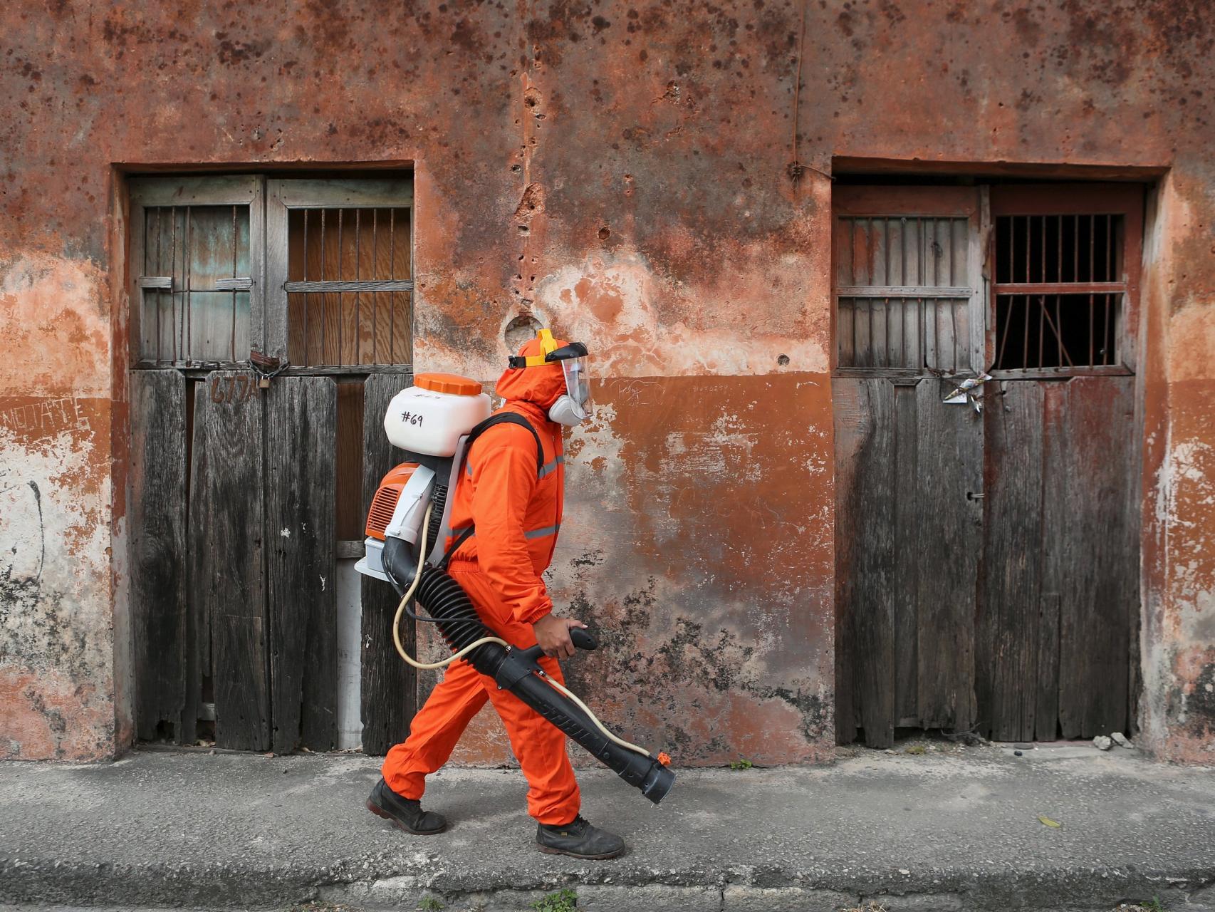 Un operario, a punto de fumigar una casa.