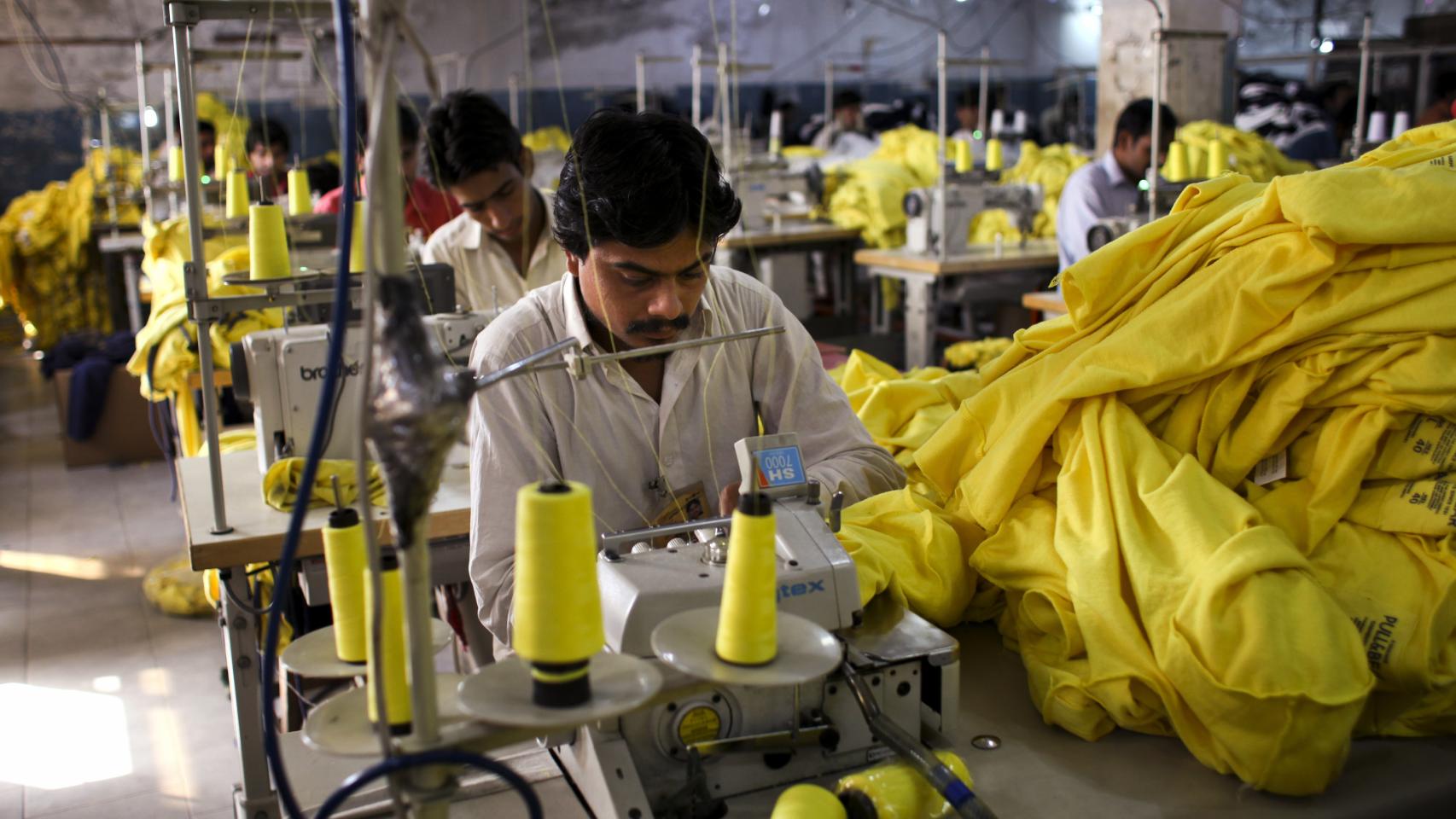 Trabajadores cosen camisetas fabricadas para Inditex en una fábrica en Pakistán.
