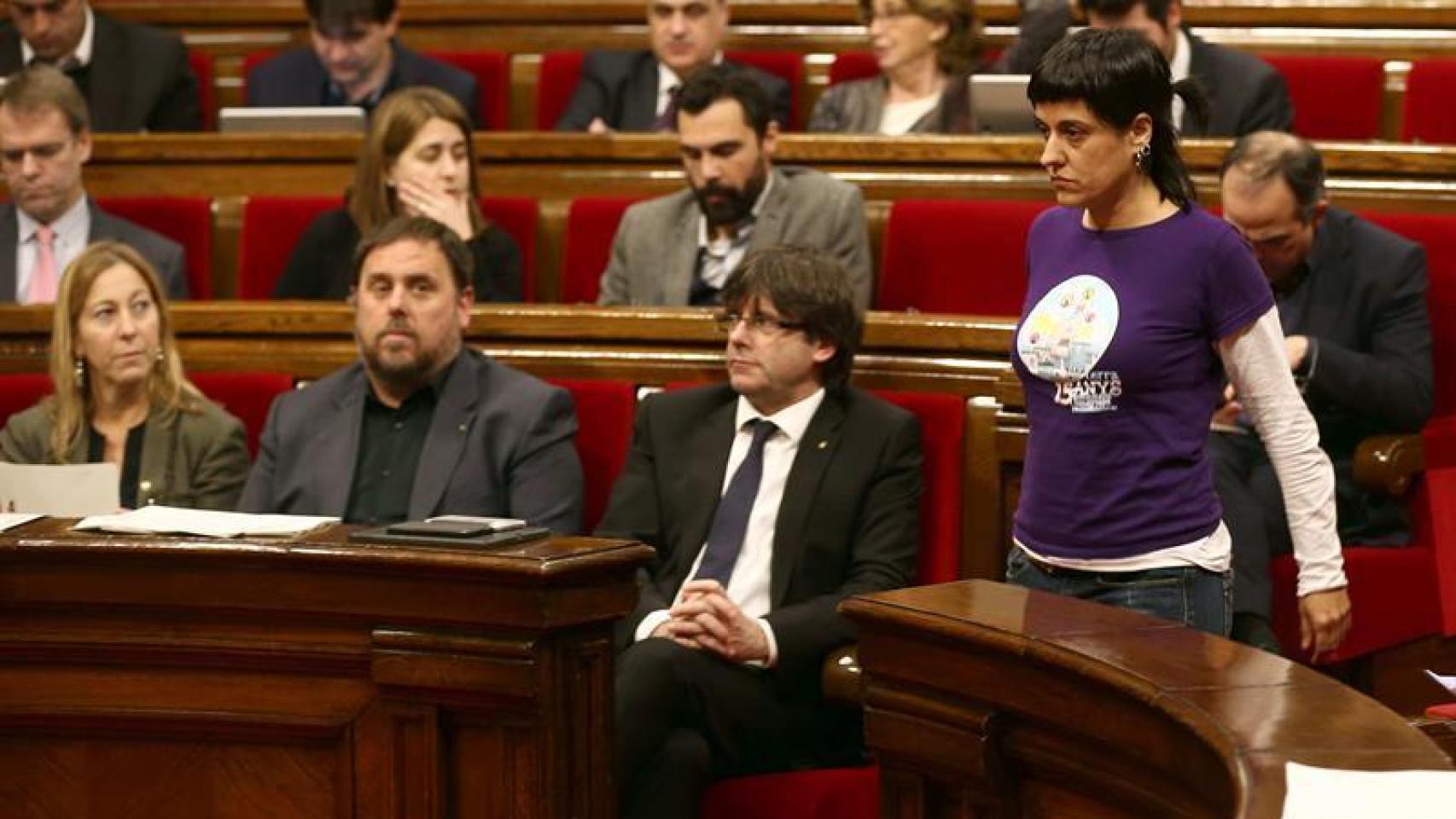 La diputada de la CUP, Anna Gabriel pasa ante el presidente de la Generalitat, Carles Puigdemont