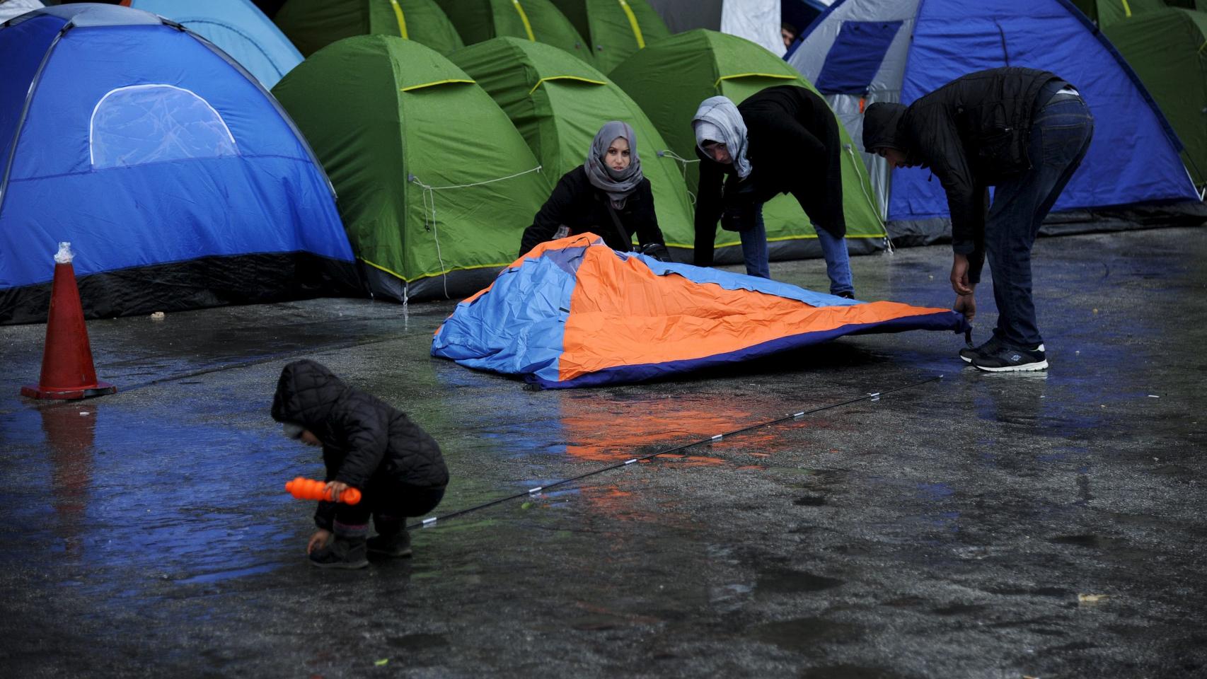 Una familia de refugiados monta una tienda en el puerto griego del Pireo