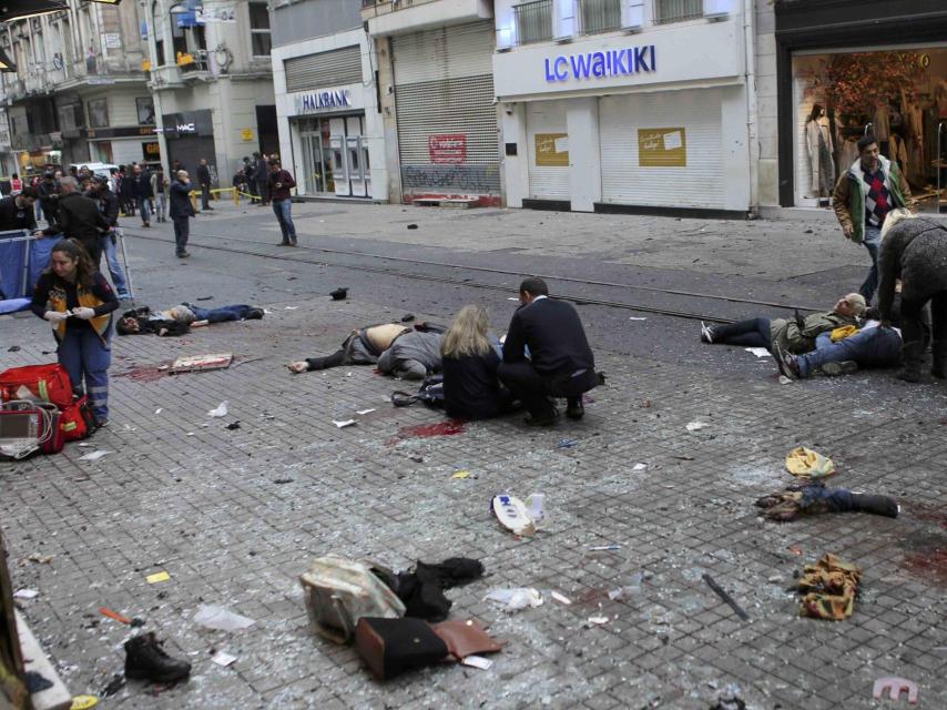 Varias personas atienden a algunos de los heridos en la explosión.