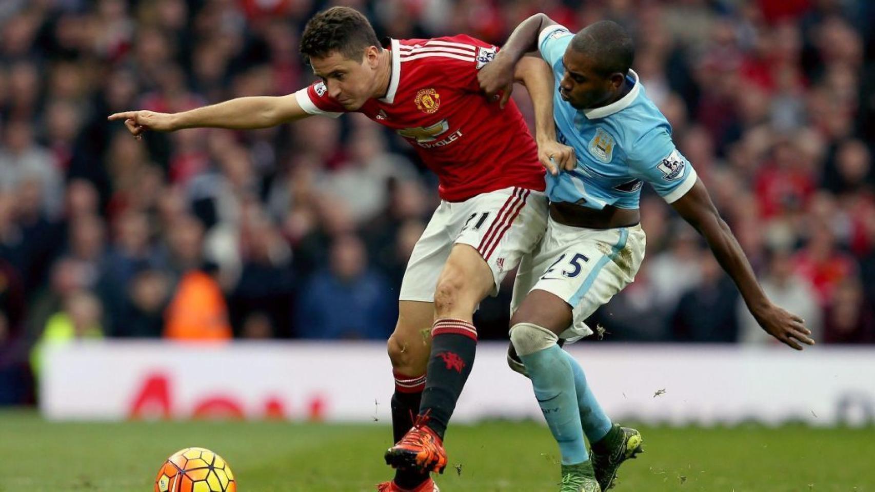 Ander Herrera y Fernandinho disputan el balón en el derbi de Manchester.