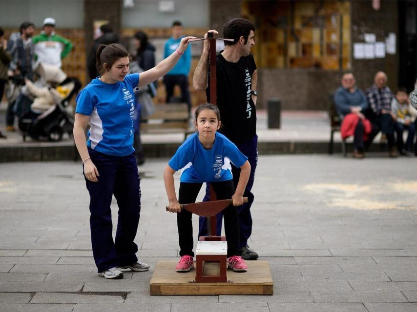 Una niña levanta un yunque.