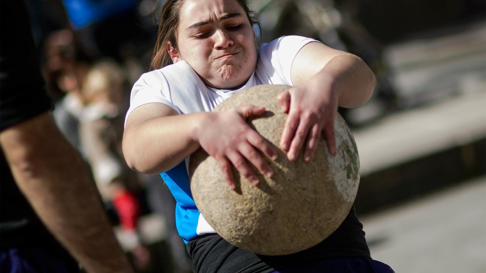 Una niña levanta una piedra.