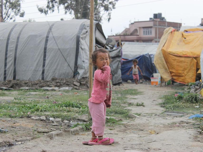 Una niña llora entre las cabañas