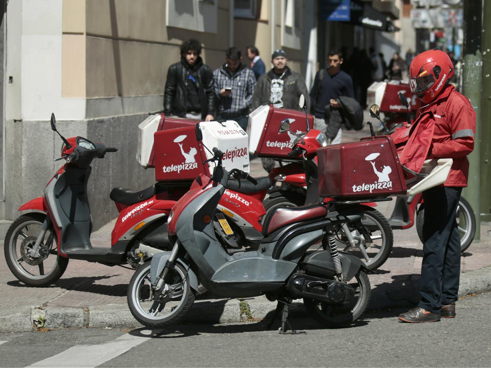 Un repartidor prepara su moto.
