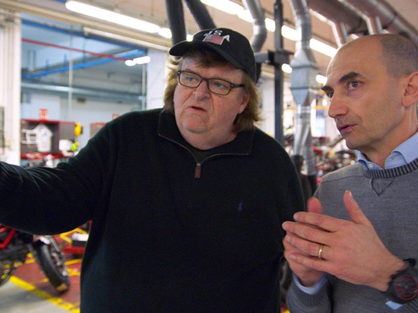 Michael Moore habla con el directivo de una empresa europea sobre las condiciones laborales.