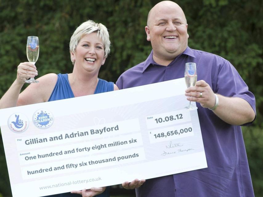 El matrimonio mostrando el cheque