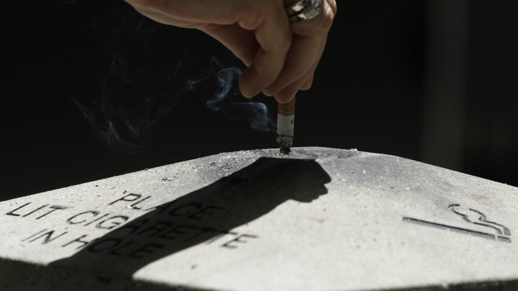Mujer apagando un cigarrillo.