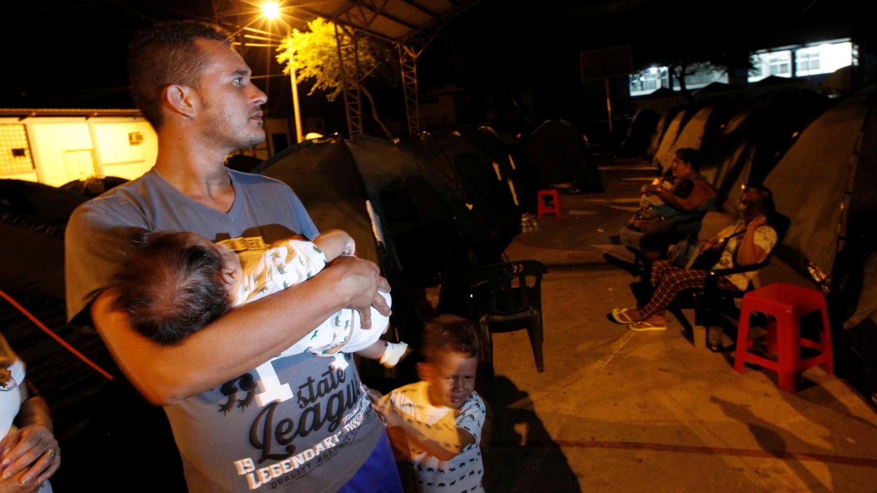 Un hombre junto a sus hijos en un colegio de Manta, Ecuador.