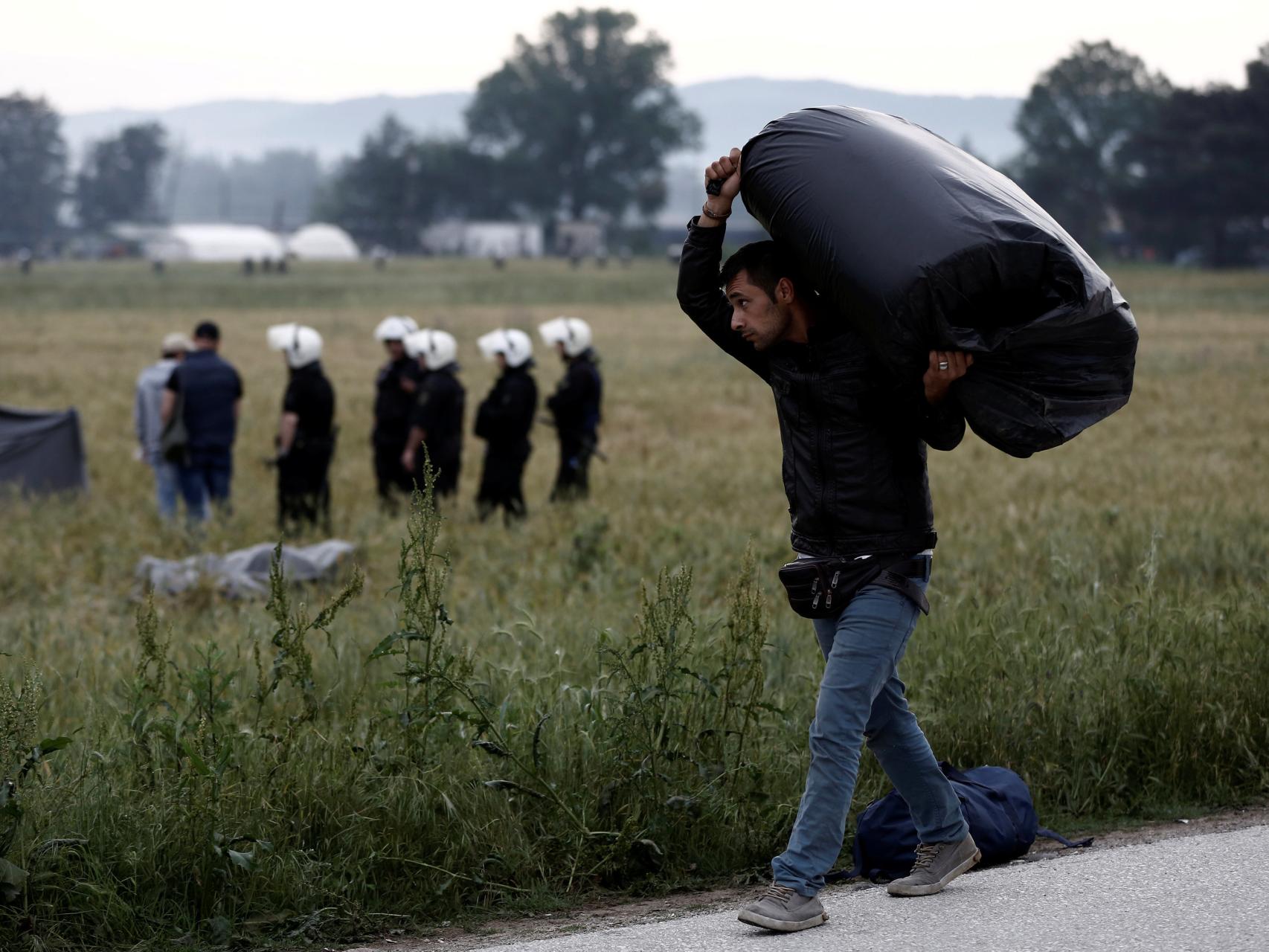 Un refugiado de Idomeni traslada sus pertenencias durante el desalojo.