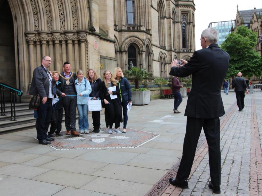 Austin-Behan haciéndose fotos frente a la puerta principal del Ayuntamiento de Mánchester.