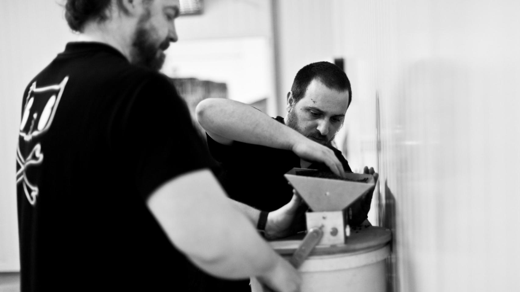Dos trabajadores se afanan en preparar la cerveza de Nómada Brewing.