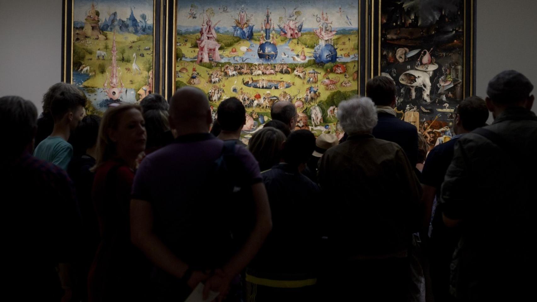 Visitantes amontonados frente al tríptico de El jardín de las delicias.