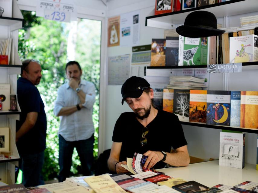 El poeta Carmelo González hojeando su libro.