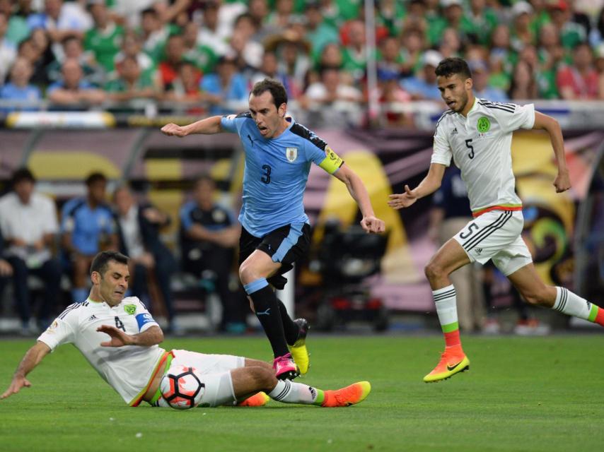 Márquez intenta cerrar el paso a Godín en el México-Uruguay.