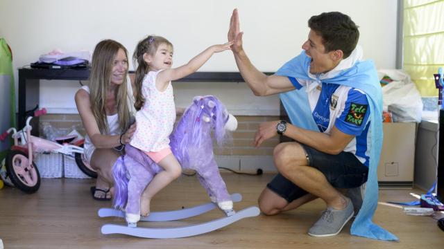 En su casa, el futbolista juguetea con la mayor de sus hijas y su mujer, Olga.